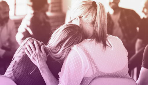 two people engaging in hug while discussing the opioid crisis