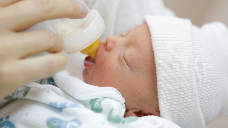 Newborn baby being bottle fed