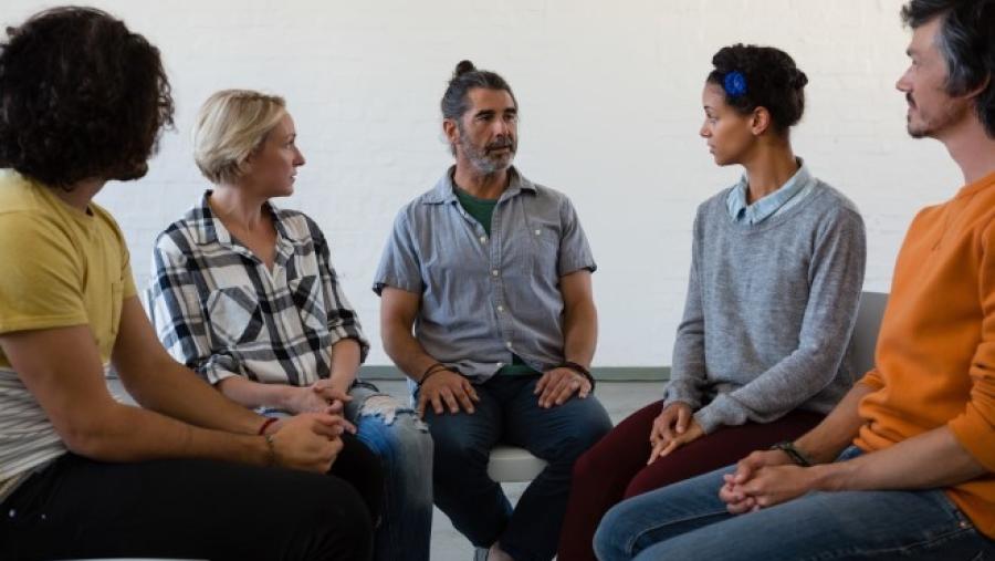 a group of people talking in group therapy