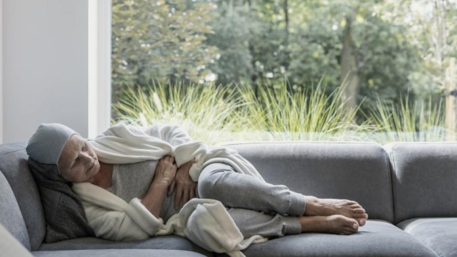 women experiencing chronic pain laying on couch